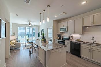 A kitchen with a large island and a ceiling fan.